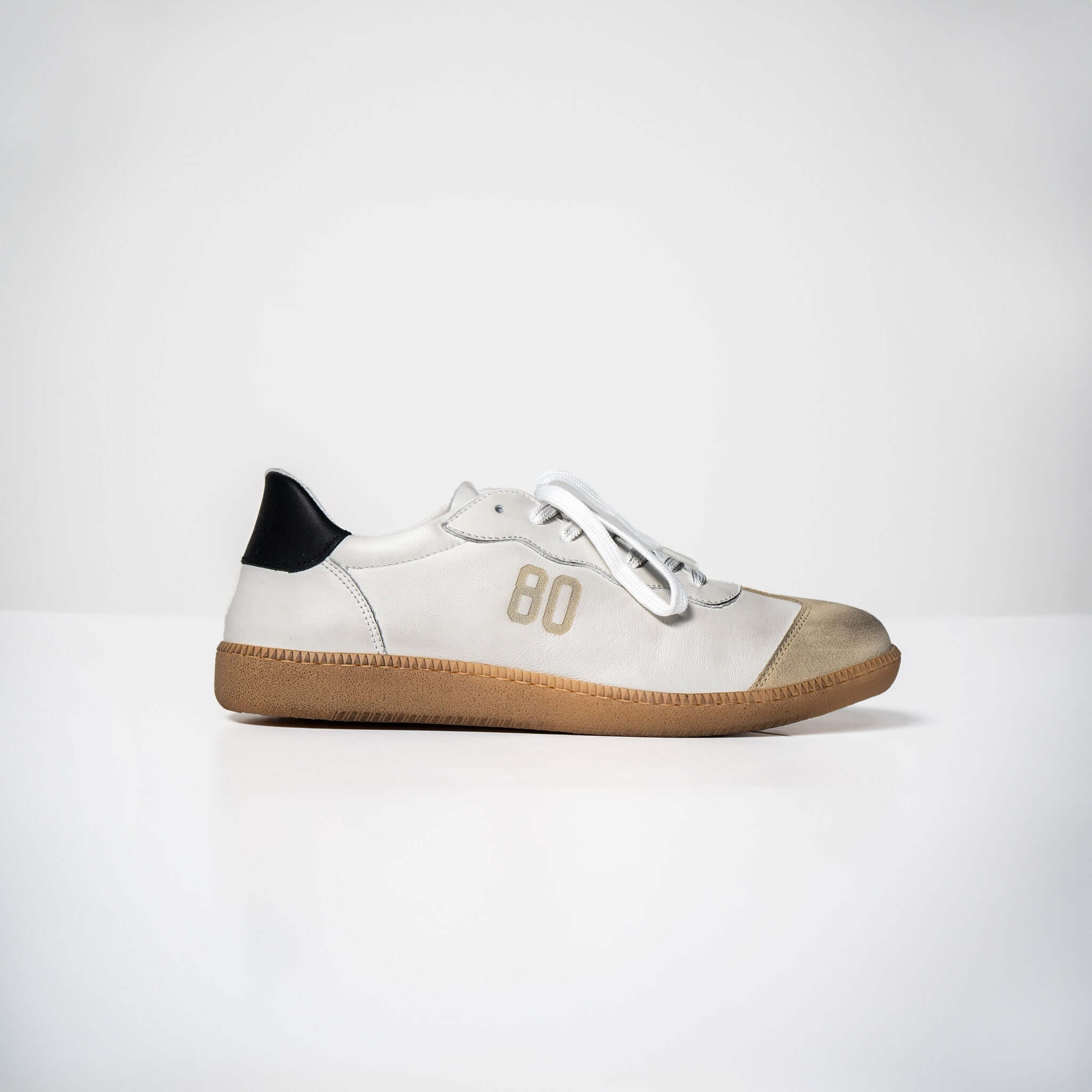 White Harvard leather sneakers with Italian rubber sole, side view displaying unique design and craftsmanship.