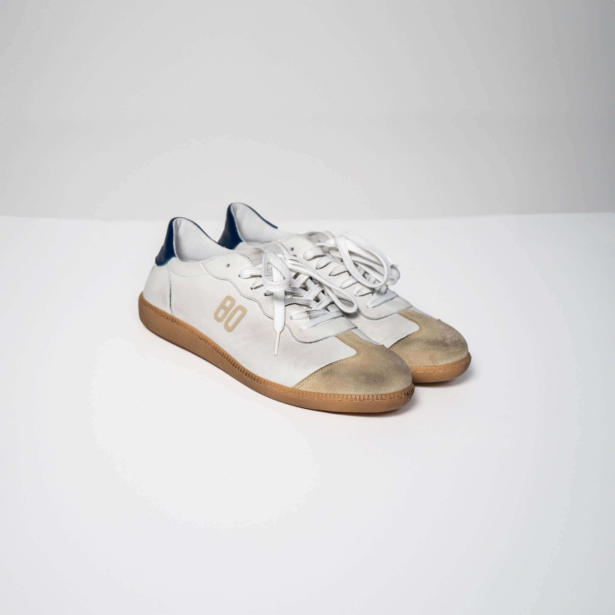 White leather Harvard sneakers with brown soles and "80" printed on the sides.