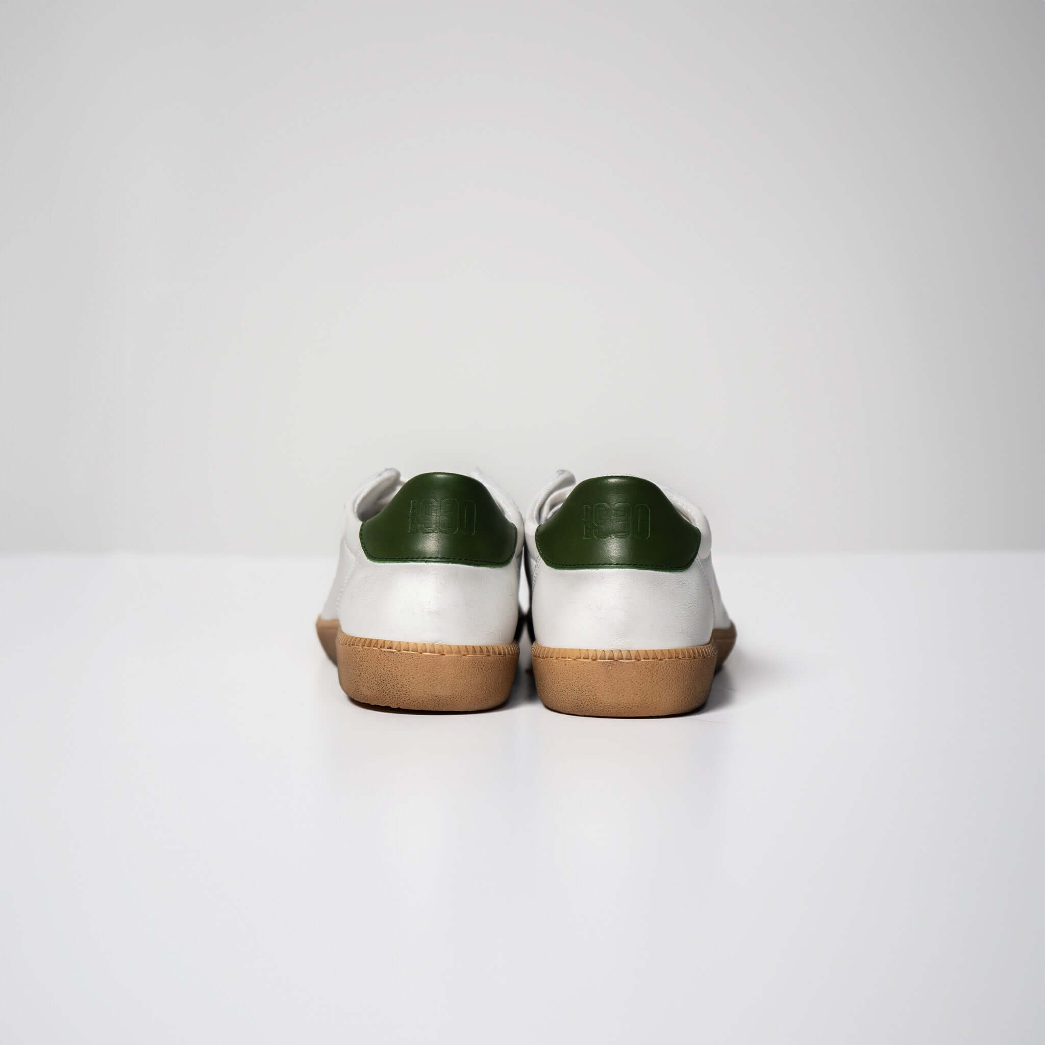 Back view of Harvard sneakers in white Italian leather with green accents and brown rubber soles, showcasing high-quality Italian craftsmanship.