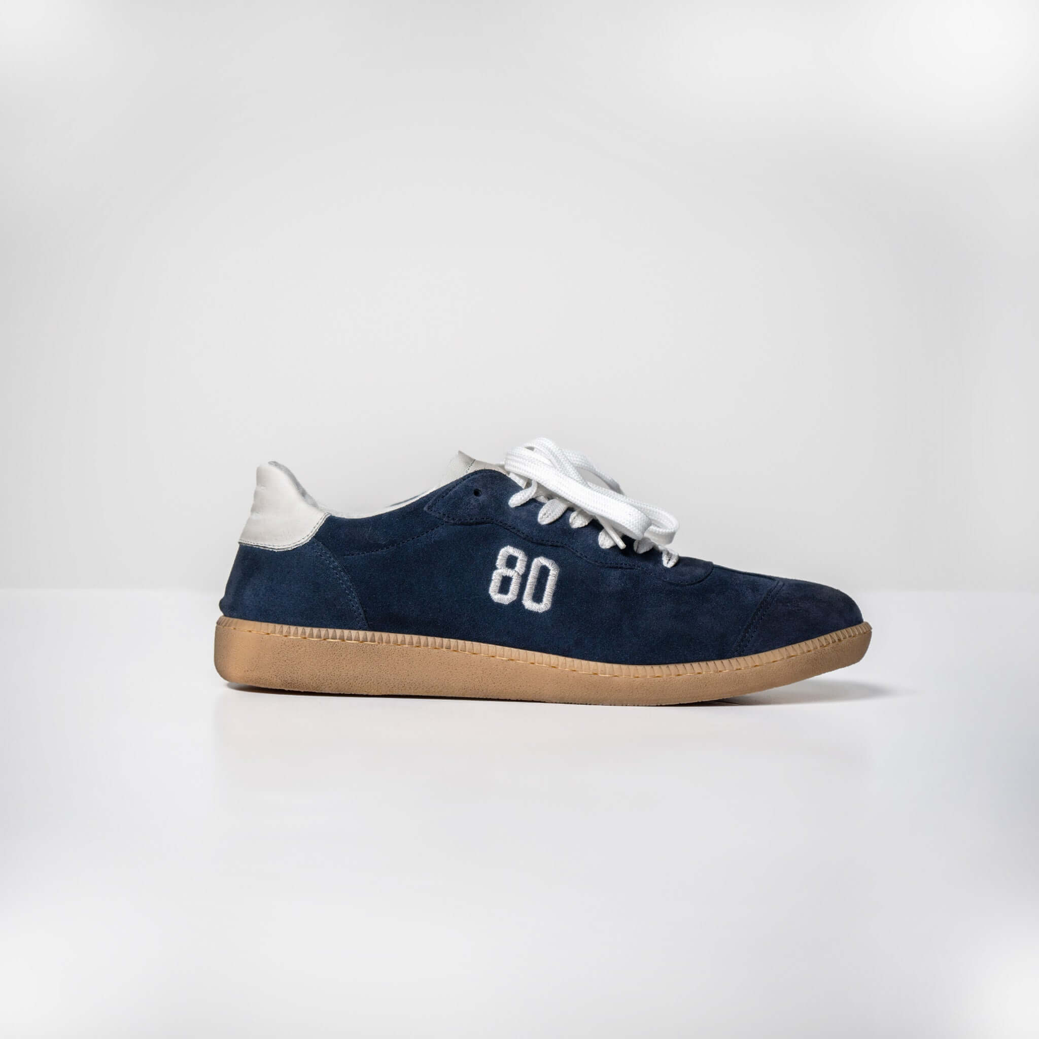 Navy blue Harvard Suede sneaker with white laces and a tan rubber sole, showing the number 80 on the side.
