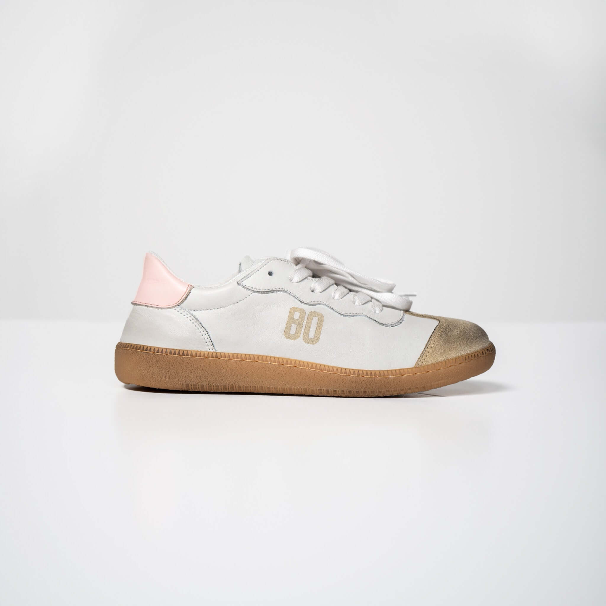 Harvard white leather sneakers with pink heel tab and brown rubber sole, displayed on a minimalistic white background.