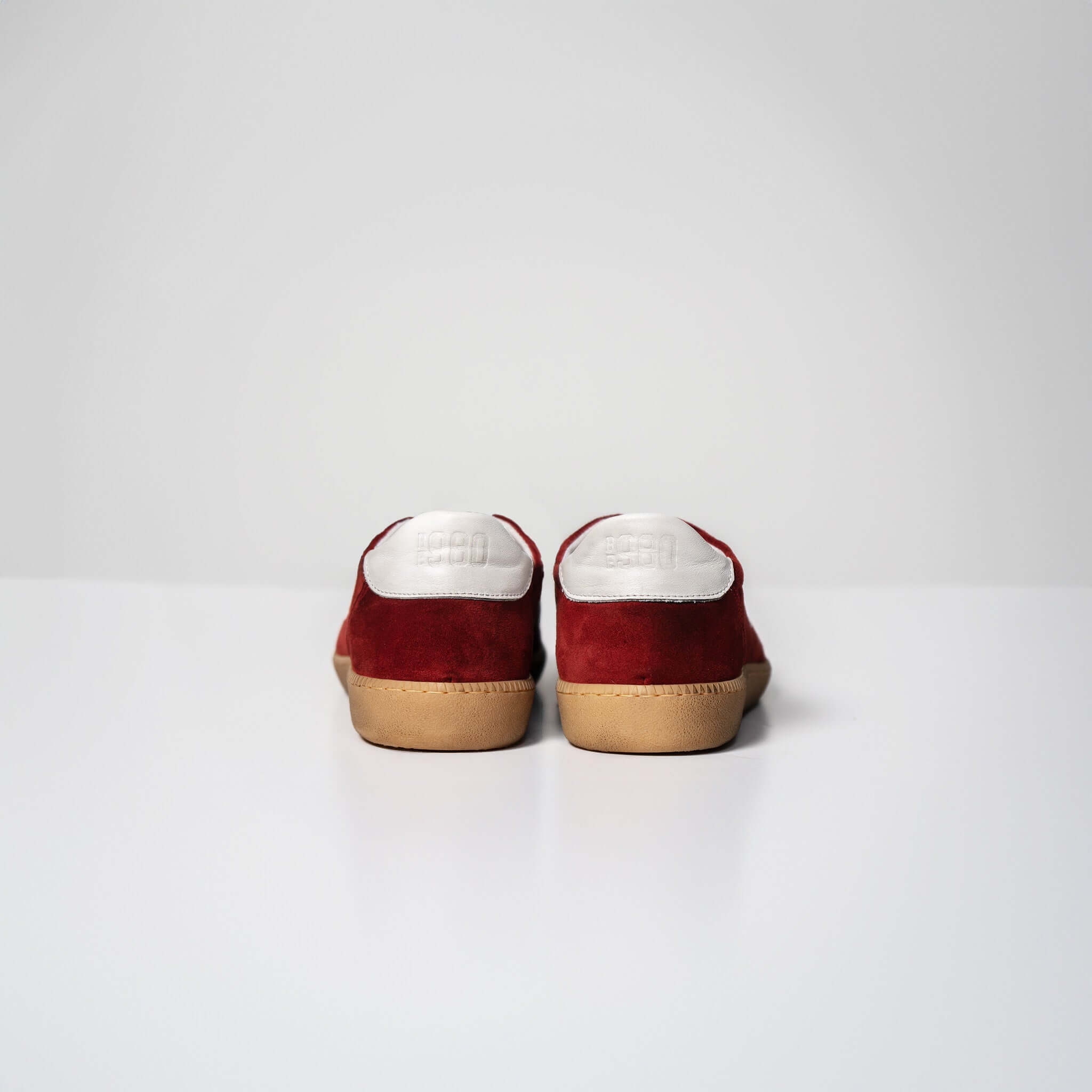 Rear view of red and white Harvard suede sneakers with Italian rubber sole, showcasing their fine craftsmanship and distinctive style.